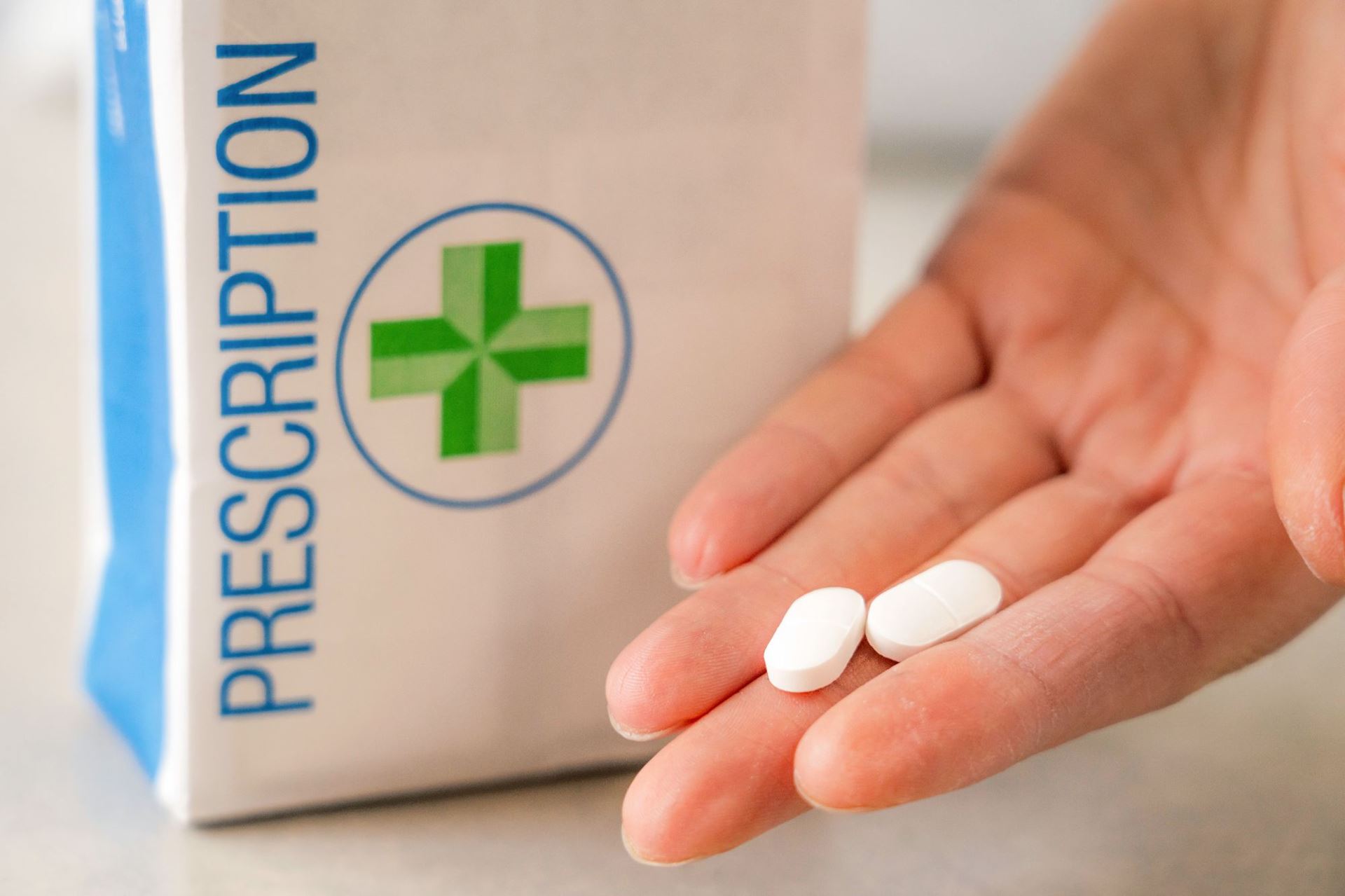 Image of Prescription Paper Bag hand holding two tablets